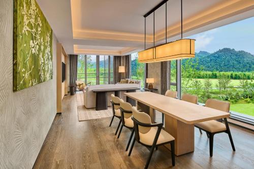 a dining room with a table and chairs and a large window at Shu Hua Hotel Tianmu Mountain, Curio Collection By Hilton in Hangzhou