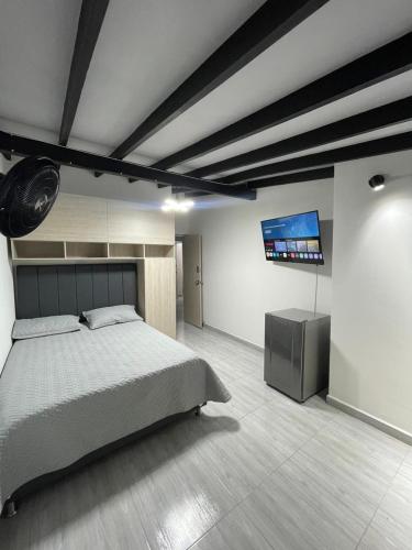 a bedroom with a bed and a flat screen tv at Hotel boutique Olaya 54 in Medellín