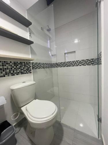 a bathroom with a toilet and a glass shower at Hotel boutique Olaya 54 in Medellín