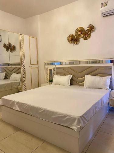 een slaapkamer met een groot wit bed in een kamer bij Appartement 211 in Dakar