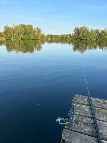 a boat tied to a dock on a lake at Direkt am See mit privatem Sandstrand in Güster
