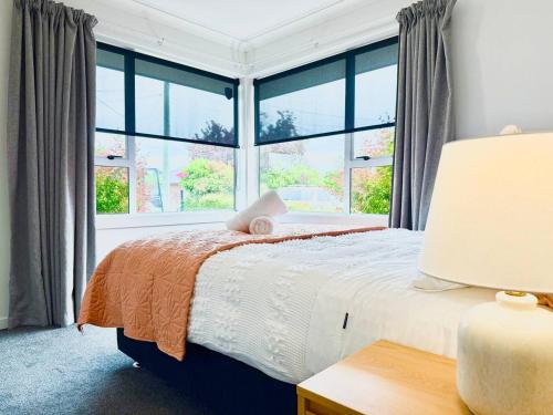 une chambre avec un lit et une grande fenêtre dans l'établissement 6 Guests Family Home 7 Minutes to Airport, à Christchurch