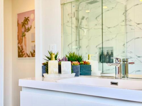 une salle de bain blanche avec un lavabo et un miroir dans l'établissement 6 Guests Family Home 7 Minutes to Airport, à Christchurch