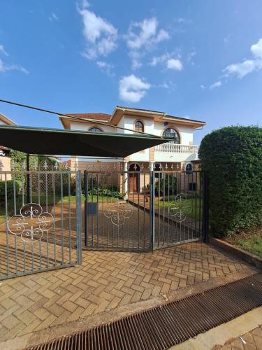 a gate with awning in front of a house at Serene Stay Near Everything in Nairobi