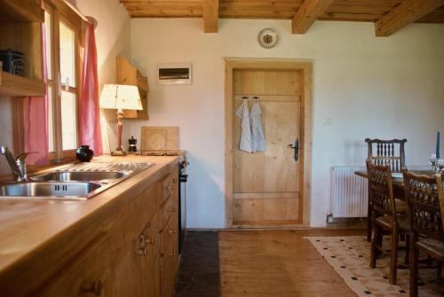 a kitchen with a sink and a door with a dress hanging on the wall at Copacis Country Home in Breb