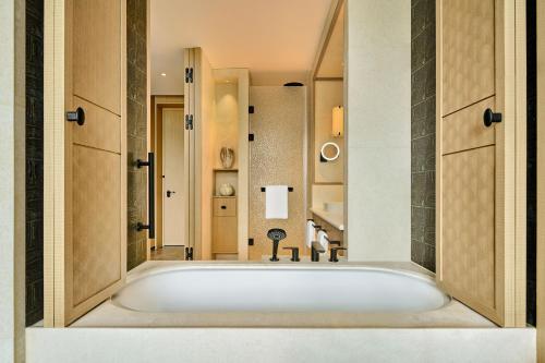 a bathroom with a large tub in a room at Shu Hua Hotel Tianmu Mountain, Curio Collection By Hilton in Hangzhou