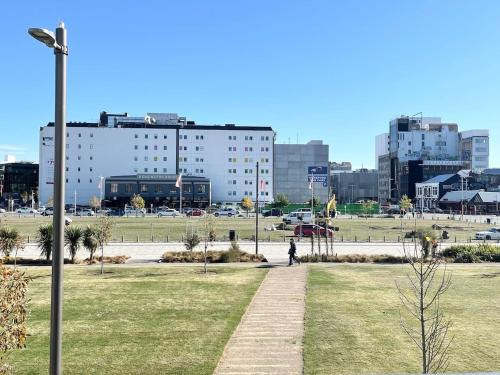 a person walking down a sidewalk in a park at CBD Bright Warm Home Free Parking in quiet complex in Christchurch