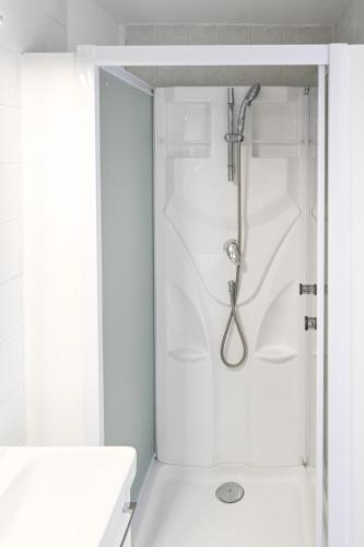 a shower in a white bathroom with a sink at Appartement - Washington 5 in Le Havre