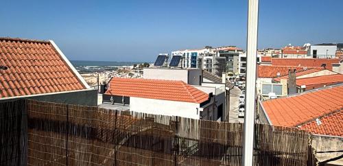 a view of a city with red roofs and the ocean at Casa das Ancoras Historic Beach Guesthouse in Buarcos Portugal in Bicas