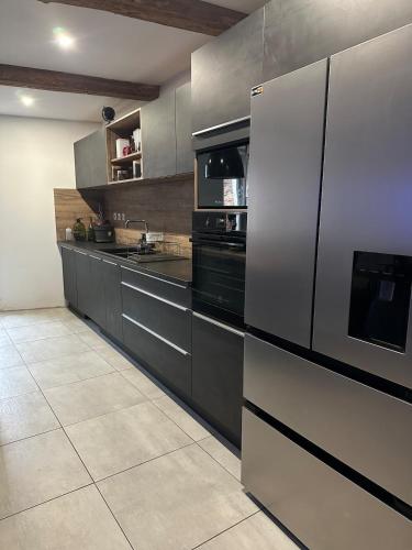 una cucina con frigorifero ed elettrodomestici in acciaio inossidabile di Asta house a Cébazan