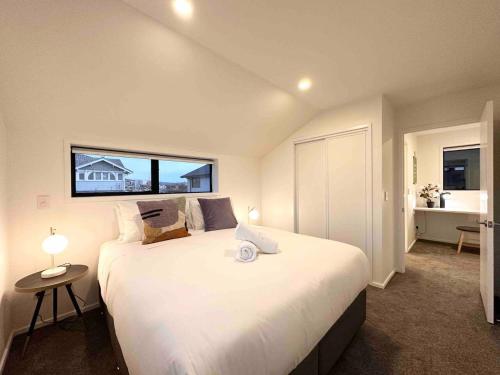 a bedroom with a large white bed with a window at Little Cutie on Worcester Quiet Stylish in Christchurch