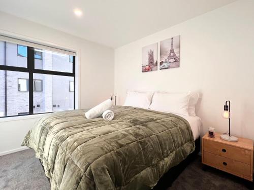 Un dormitorio con una cama grande y una ventana. en Premium Location 2beds2bath on Madras, en Christchurch