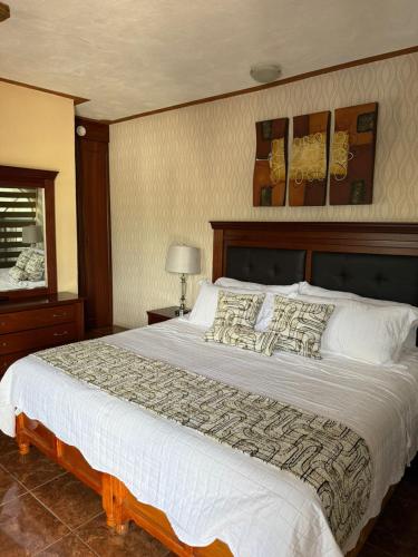 a bedroom with a large bed with white sheets and pillows at Hotel Villa Bernal in Bernal