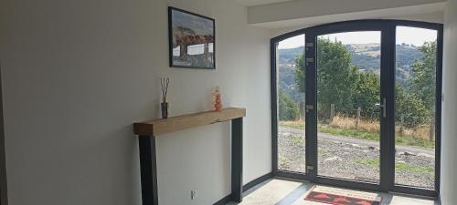 Zimmer mit einer offenen Tür und einem Fenster in der Unterkunft Cottage au cœur de l'Aubrac in Saint-Chély-dʼAubrac