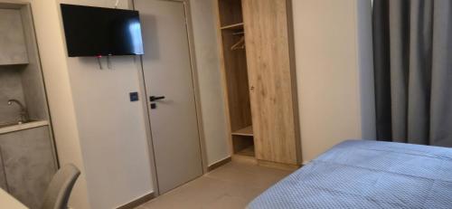 a room with a bed and a television on a door at Thalori Suites in Kalamata