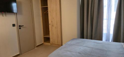 a bedroom with a bed and a closet with a window at Thalori Suites in Kalamata