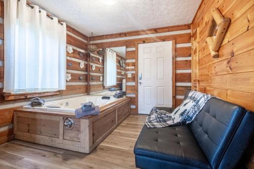 a large bathroom with a tub and a couch at Dogwood's Smoky Mtn Cabin Hot Tub And Views in Sevierville