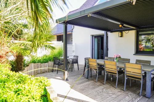 a patio with a table and chairs under awning at Les Bleuets - Erdivines in Erdeven