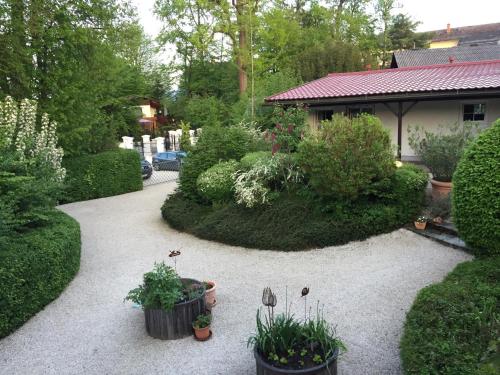 a garden with potted plants and a house at Appartements im Park in Krumpendorf am Wörthersee
