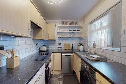 a kitchen with a sink and a counter top at Modern 2 Bed Near Twickenham Stadium - 5 Min to Bus Stop in Hanworth