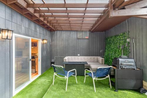 a patio with two chairs and a grill at Garden Suite Two Bedroom with Hot Tub Sauna Outdoor kitchen and Game Room in Everett