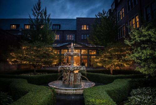 a fountain in a garden in front of a building at Royal Park Hotel in Rochester