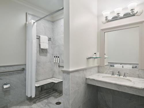 a white bathroom with a sink and a mirror at Royal Park Hotel in Rochester