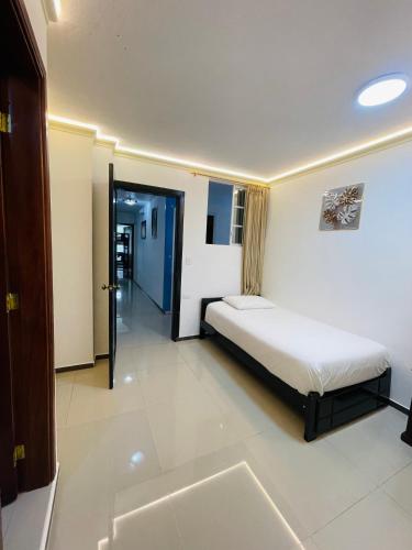 a bedroom with a bed and a door to a hallway at Hostal Balcon del Cielo in Baños