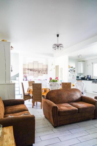 a living room with two couches and a dining room at Les Bleuets - Erdivines in Erdeven