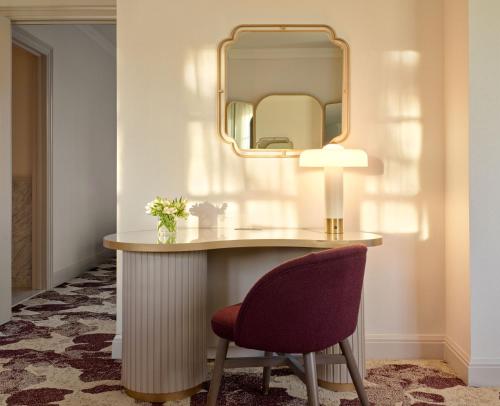 a dressing table with a chair and a mirror at Royal Park Hotel in Rochester