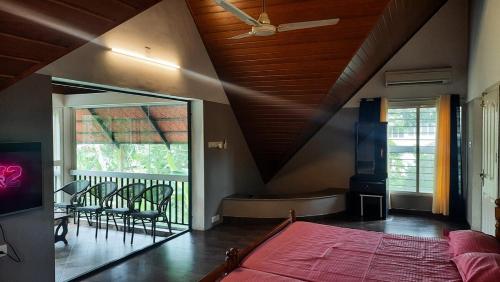 a bedroom with a bed and a balcony with a tub at Cottage on Riverside in Irinjālakuda