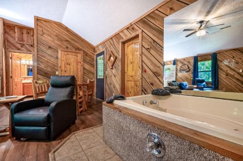 a bathroom with a tub and a chair in a room at Couples Getaway Hot Tub & Mountain View in Sevierville
