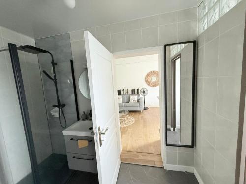 une salle de bain avec une douche, un lavabo et un miroir dans l'établissement Chez Tom et nina, à Lagord