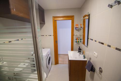 Un baño con lavabo y lavadora. en Maravilla Tranquila Apartment, en Costa del Silencio