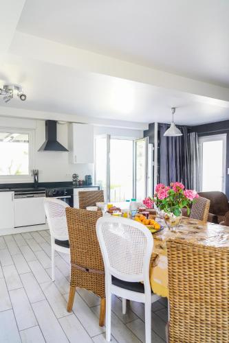 a kitchen and dining room with a table and chairs at Les Bleuets - Erdivines in Erdeven