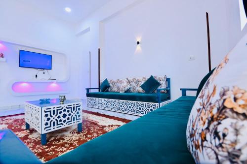 a living room with a couch and a tv at SunWing guest house in Luxor