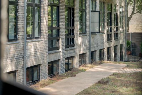 a brick building with a sidewalk in front of it at No186 apartments by Daniel&Jacob's in Copenhagen