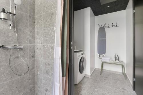 a bathroom with a shower and a washing machine at No186 apartments by Daniel&Jacob's in Copenhagen