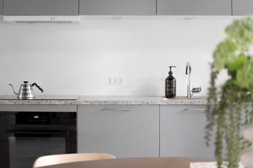 a kitchen with white cabinets and a counter with a sink at No186 apartments by Daniel&Jacob's in Copenhagen