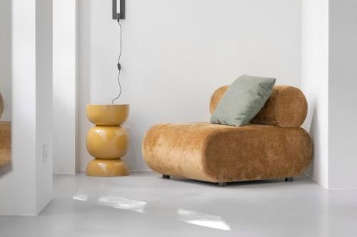 a living room with a brown chair and a vase at No186 apartments by Daniel&Jacob's in Copenhagen