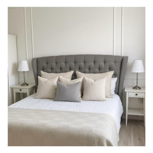 a white bedroom with a large bed with white pillows at Eastbury House near Garryvoe Hotel & Ballymaloe House in Cork