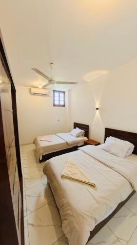 a bedroom with two beds and a ceiling at SunWing guest house in Luxor