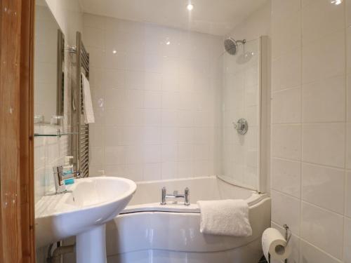 a white bathroom with a sink and a tub and a sink at Hambleton House in Derby