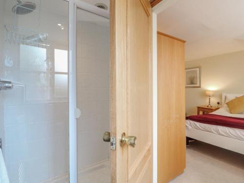 a bathroom with a shower and a glass door at Hambleton House in Derby