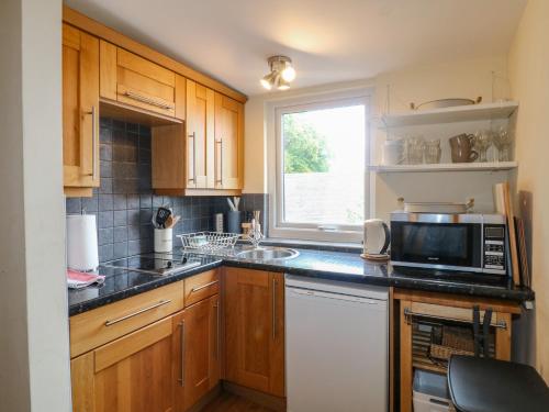 a kitchen with a microwave and a sink and a window at Hambleton House in Derby