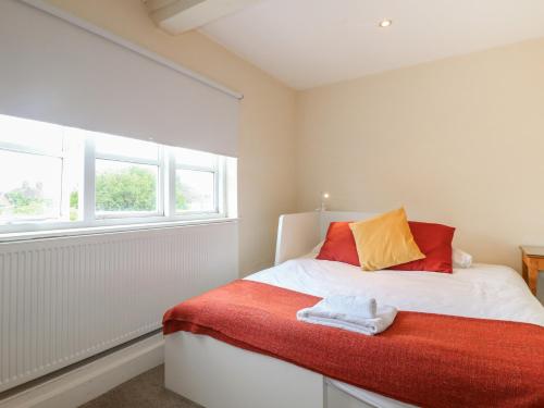 a bedroom with a bed with a red blanket and a window at Hambleton House in Derby