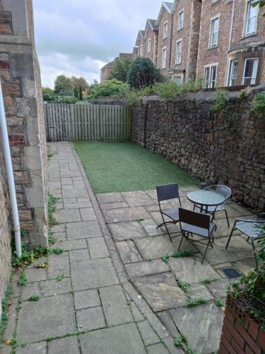 a patio with two chairs and a table in a yard at Beaufort House Apartments from Your Stay Bristol in Bristol