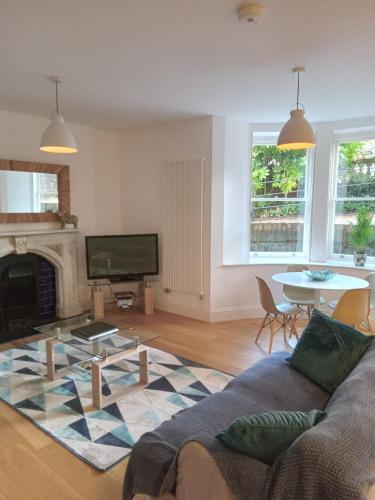 a living room with a couch and a fireplace at Beaufort House Apartments from Your Stay Bristol in Bristol