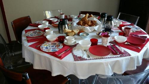 una mesa con platos rojos y blancos y comida en ella en Les Voies Blanches, en Vouvray