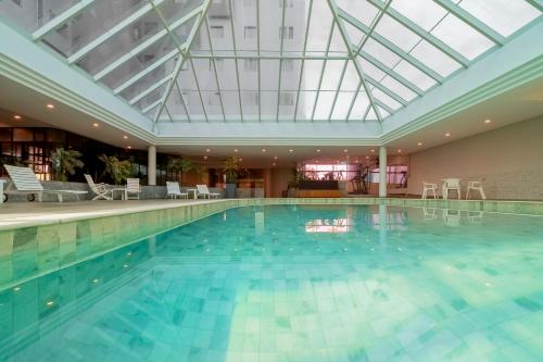 a large swimming pool with a glass ceiling at ibis Styles Sorocaba Santa Rosalia in Sorocaba